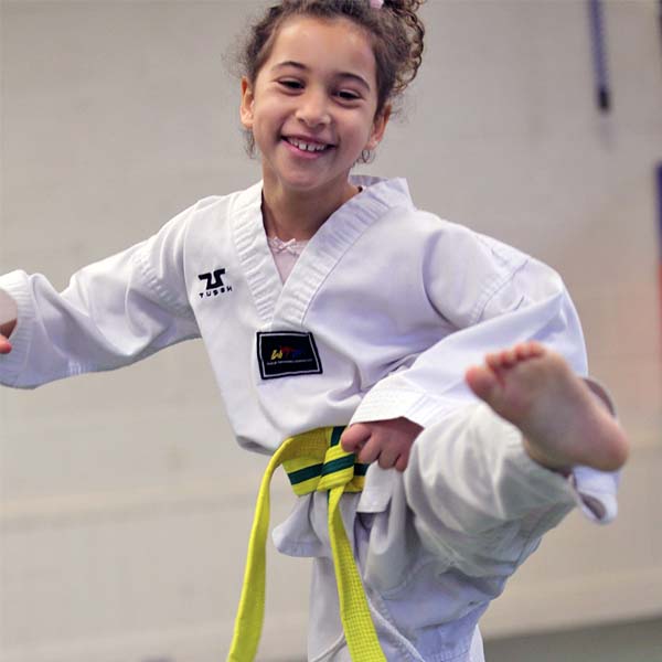 Leeds taekwondo girl smiling and kicking